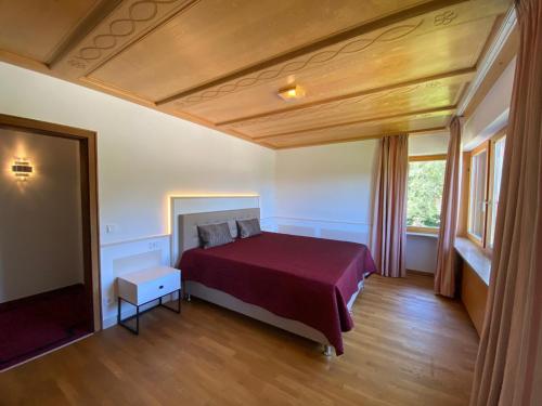 1 dormitorio con 1 cama con colcha roja en Villa Hochbahn in Schönau am Königssee, en Schönau am Königssee
