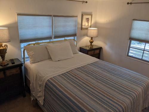 ein Bett in einem Schlafzimmer mit zwei Lampen und zwei Fenstern in der Unterkunft Resort 2 in Mabank