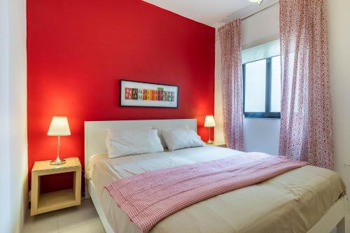 a red bedroom with a bed and a window at Stunning - Seafront 3-Bedroom 6th Floor in Sliema