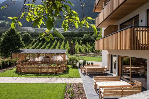 a house with a garden with wooden benches at Oberfallerhof Apartment Inni in Barbiano