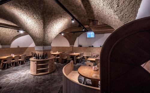 a restaurant with wooden tables and chairs in a room at Oberfallerhof Apartment Inni in Barbiano