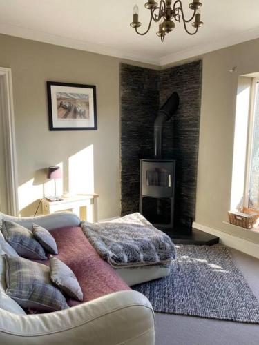sala de estar con sofá y chimenea en Beautiful Cottage in the Yorkshire Dales en Leyburn