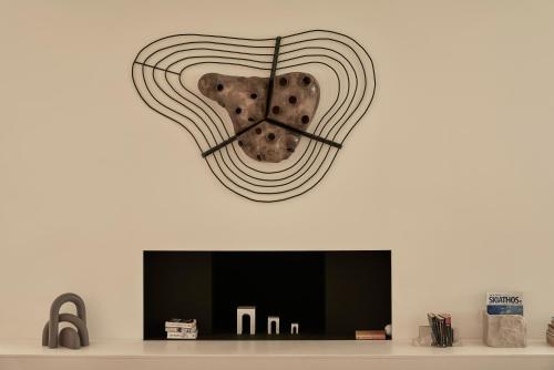 a large clock on a wall above a tv at Radisson Resort Plaza Skiathos in Kanapitsa