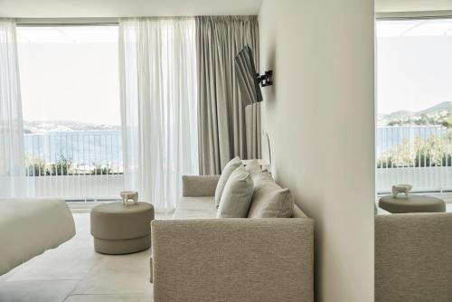 a living room with a couch and some windows at Radisson Resort Plaza Skiathos in Kanapitsa