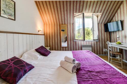 a bedroom with a large bed with towels on it at Auberge de l'Étable in Montory