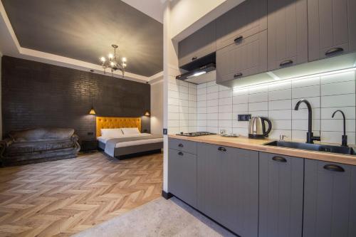 a kitchen with a sink and a couch in a room at Idea Design Apart-Hotel Prorizna in Kyiv