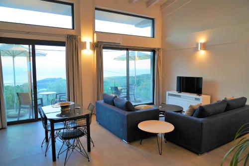 a living room with couches and a table and a tv at Moonlight Suites in Parga