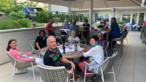 a group of people sitting at a table in a restaurant at Fichtenwald-Ihr Boutique I Glück`s Hotel in Bad Füssing