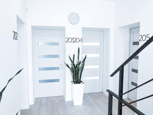 um corredor branco com uma planta numa porta branca em Klaster SeaView Hotel em Chornomorsk