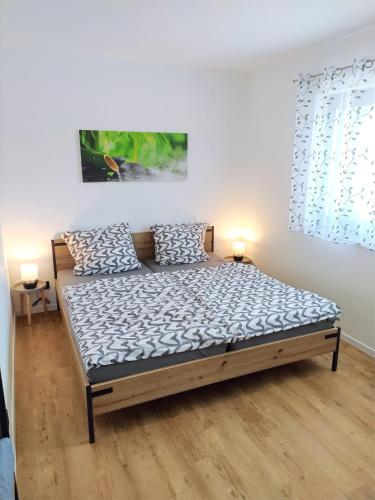 a bed in a room with two pillows on it at FeWo Wildflecken - Ferienwohnung Rhön Neubau 2021 in Wildflecken