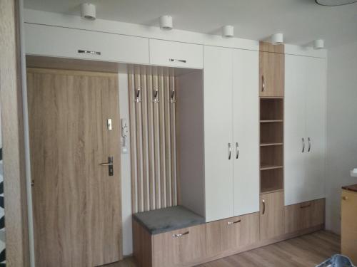Habitación con armarios blancos y puertas de madera. en Apartament ZDRÓJ, en Busko-Zdrój
