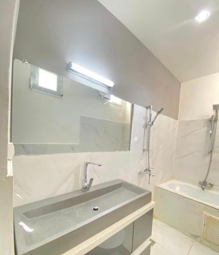 a bathroom with a sink and a mirror and a tub at Appartement haut standing idéalement situé à Dakar in Dakar