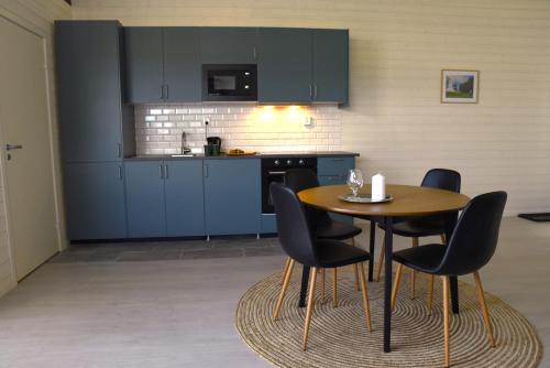 uma cozinha com mesa e cadeiras num quarto em Kungälv-Kode Golf Club Apartments em Kode