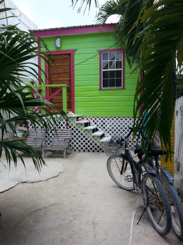 a bike parked in front of a green house at Sea n sun Guest House in Caye Caulker