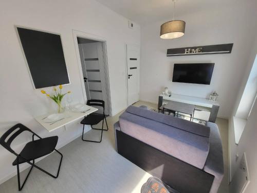 - un salon avec un lit, une table et des chaises dans l'établissement Ottimo Apartamenty Dolina, à Bydgoszcz