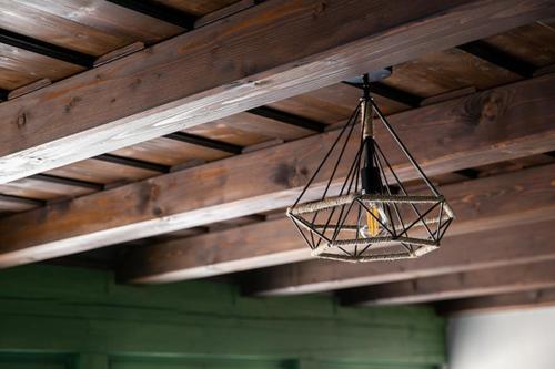 a hanging light hanging from a wooden ceiling at Borostyán Porta Lesencetomaj in Lesencetomaj