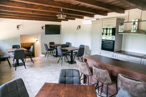 a kitchen with tables and chairs in a room at Borostyán Porta Lesencetomaj in Lesencetomaj