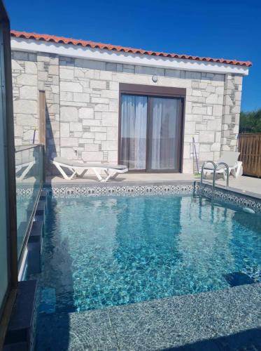 a swimming pool in front of a house at Kolymbia Village in Kolimbia