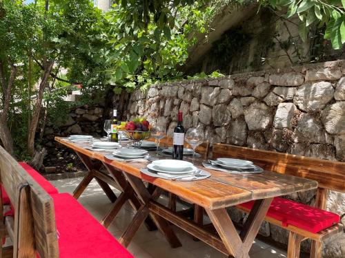 a wooden table with plates and a bottle of wine at Holiday Home Blanka in Neum