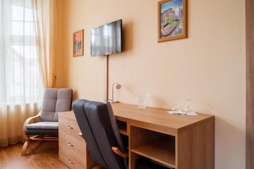 a room with a desk and a chair and a television at Villa A. Malka in Poděbrady