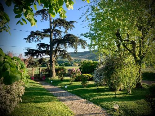 JuliénasにあるLove Room du Pavillon Gite indépendant avec SPA à 50 min de Lyon dans le Beaujolaisの木々や花の咲く庭園内の小道