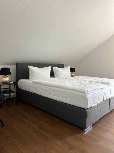a bedroom with a large bed with white sheets and pillows at Hotel Teatro in Kassel