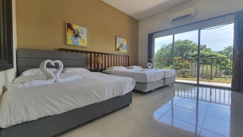 two swan beds in a bedroom with a balcony at Gold Coast Morib Studio l Apartment I Penthouse in Banting