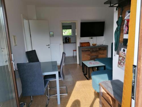 a living room with a table and chairs and a television at FEWO an der Brücke in Stubenberg