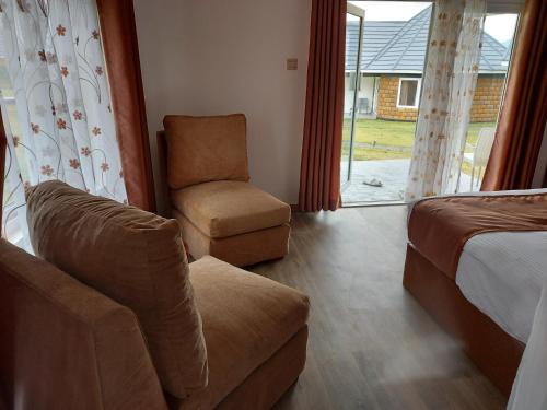 a bedroom with a couch and a chair and a window at VICTORIA SANDS LODGE in Mbita
