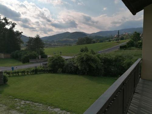 a balcony with a view of a field and a road at FEWO an der Brücke in Stubenberg