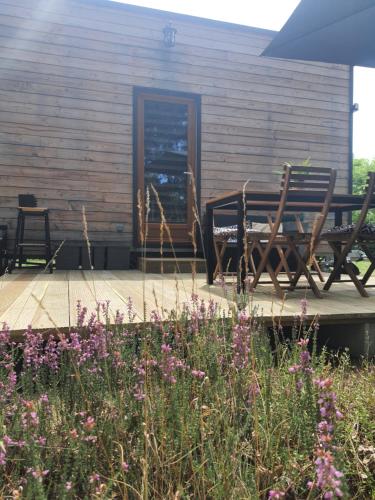 a patio with two chairs and a table and flowers at Domaine Pinsol in Uchacq-et-Parentis