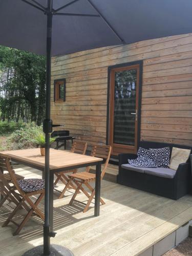 a patio with a table and chairs and an umbrella at Domaine Pinsol in Uchacq-et-Parentis