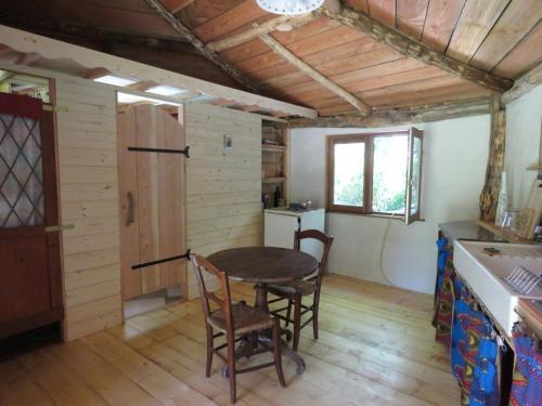 une cuisine avec une table et des chaises dans une pièce dans l'établissement Tente suspendue au coeur de la forêt, à Sainte-Croix-de-Volvestre