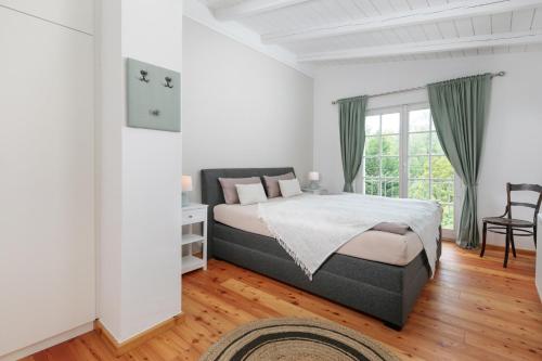 Atelierhaus auf der Insel Werder mit Garten, W-Lan und Netflix في Gallin: غرفة نوم بيضاء بها سرير ونافذة