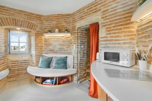 une cuisine avec un comptoir, une chaise et un four micro-ondes dans l'établissement La Tour du Capitole, cocoon insolite dans Toulouse, à Toulouse