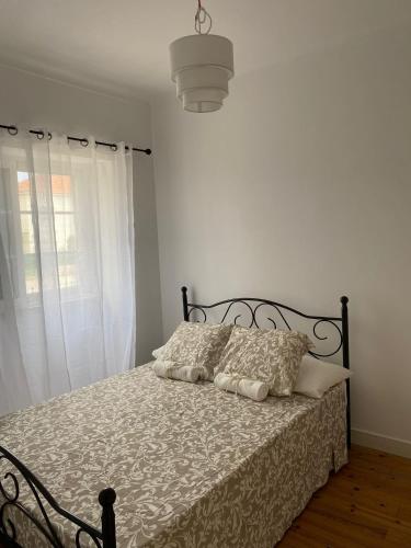 a bedroom with a bed with a black frame and pillows at Travelers House in Setúbal