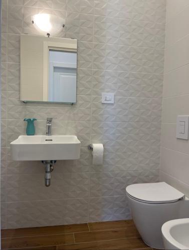 a bathroom with a sink and a toilet and a mirror at Carlino's Home in Salerno
