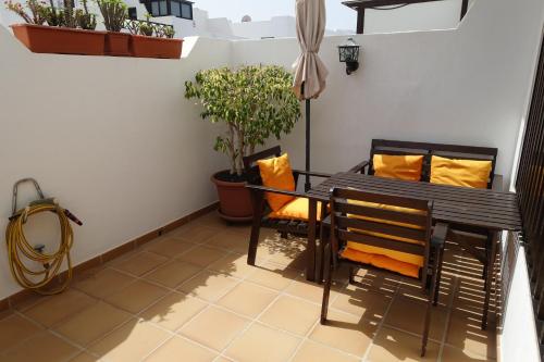 einen Balkon mit einem Tisch, Stühlen und Topfpflanzen in der Unterkunft Apartamento Remo in Playa Honda