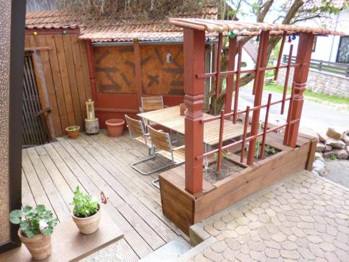 une terrasse en bois avec une table et un banc dans l'établissement Ferienwohnung Vreni, à Gersfeld