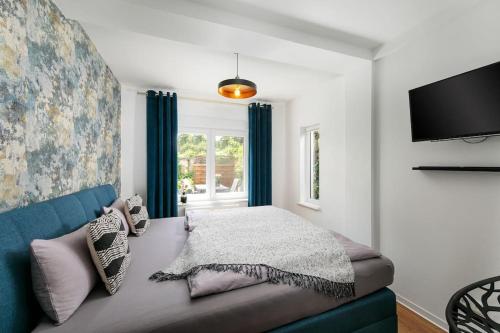 1 dormitorio con sofá azul y TV en charmantes Townhaus mit Garten, W-LAN & Netflix, en Potsdam