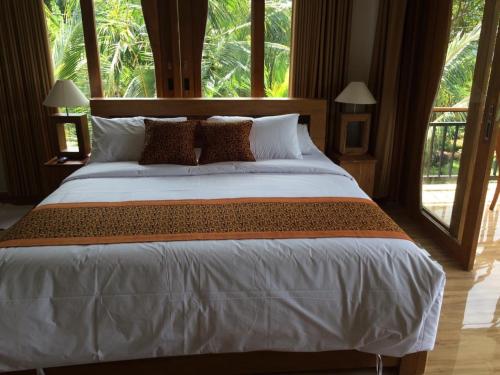 a large bed in a room with a large window at Villa - Warung AromaChampuhan in Mayong