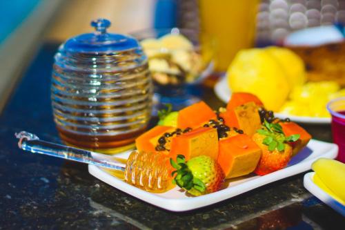 a plate of fruit and vegetables on a table at Hotel Dan Inn Uberaba & Convenções in Uberaba