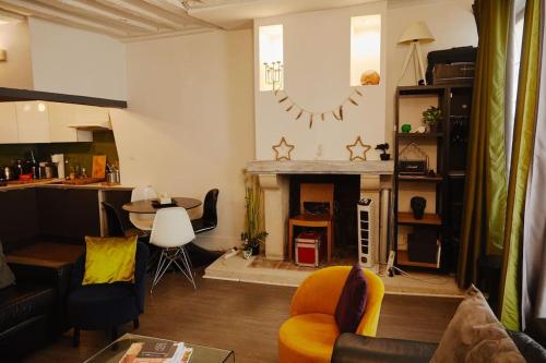 un salon avec une cheminée et une table dans l'établissement Cozy 2-Pièces au Coeur du Haut-Marais, à Paris