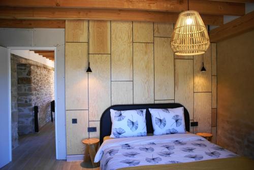 a bedroom with a bed and a chandelier at vakantiewoning Odiel & Gabrielle in Montchevrier