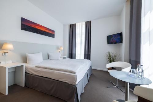 ein Hotelzimmer mit einem Bett und einem Tisch in der Unterkunft Hotel KO15 in Lübeck