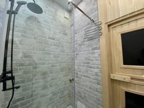 a shower in a bathroom with a brick wall at European Village Old Villa 6 in Gonio