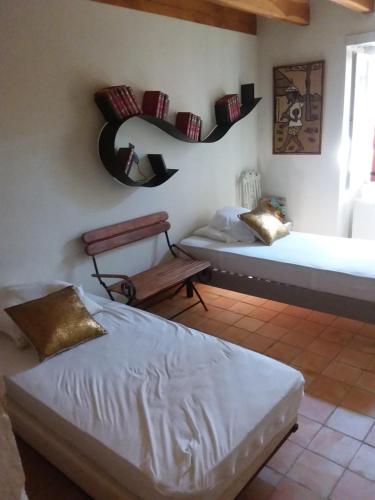 une chambre avec deux lits et un miroir au mur dans l'établissement Maison 18eme siècle, à Le Moulinaud