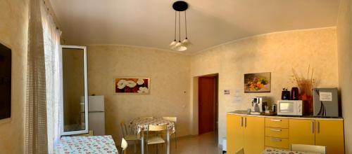 a kitchen with a yellow counter and a table at Ligo in Villanova dʼAlbenga