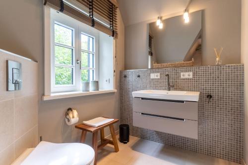 ein Badezimmer mit Waschbecken und Spiegel in der Unterkunft Einzelhaus Boathouse Boathouse in Sankt Peter-Ording