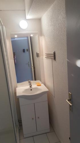 y baño con lavabo blanco y espejo. en Appartement Vaux sur mer, en Vaux-sur-Mer